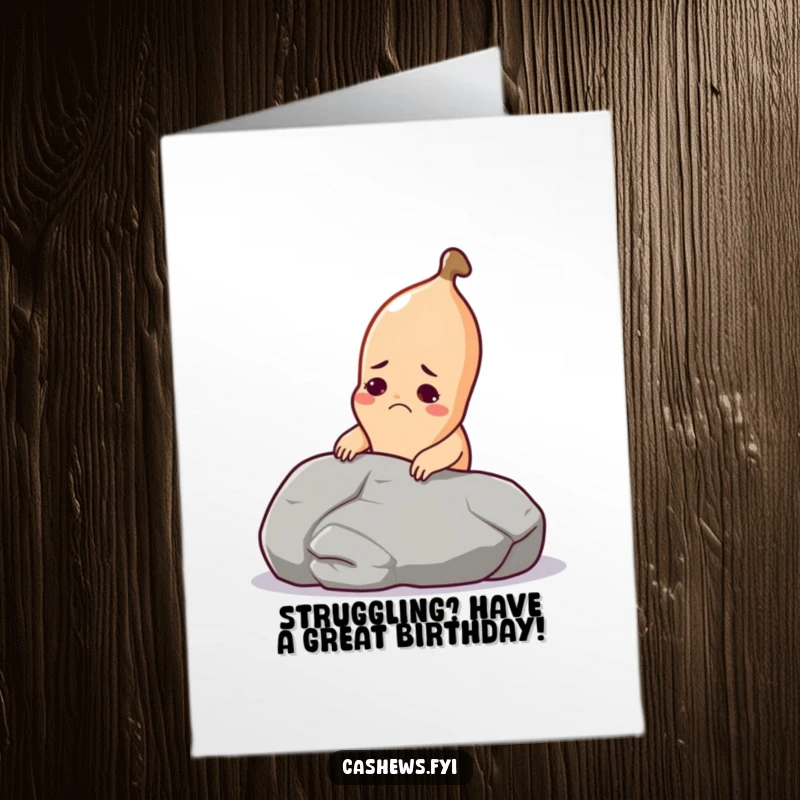 Funny free printable birthday card: a cashew grimaces trying to lift a huge pebble, a true test of strength.